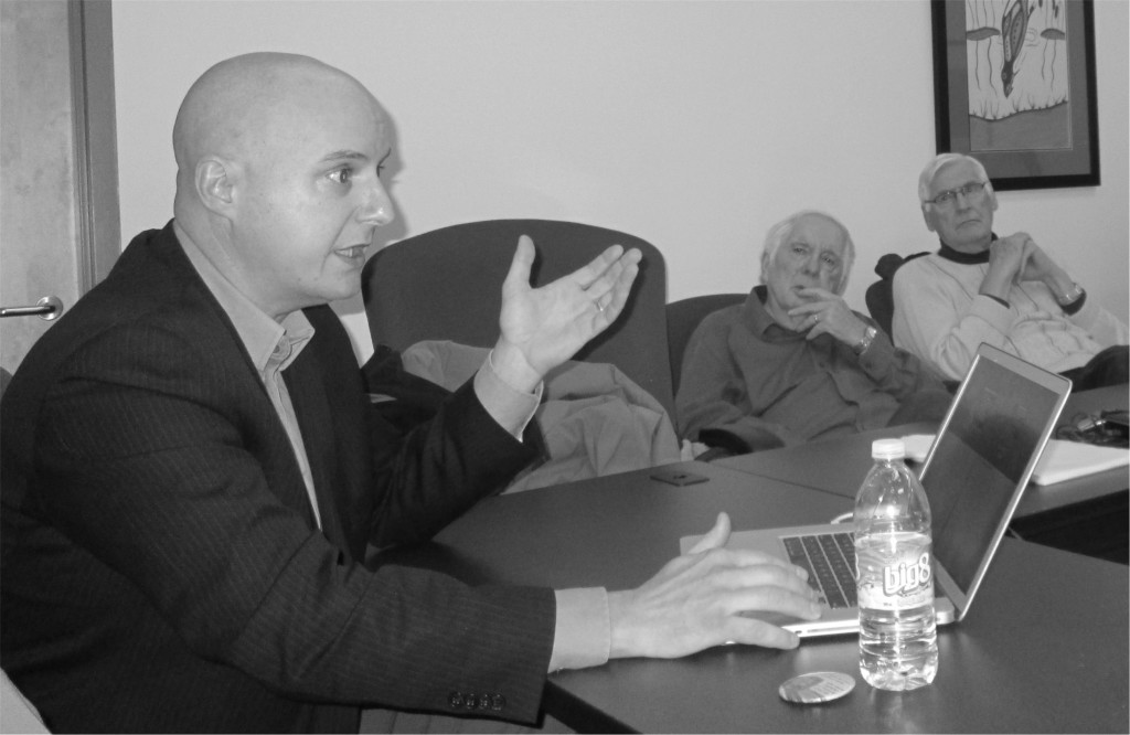 Dr Yves Bourgeois at a table, in discussion.